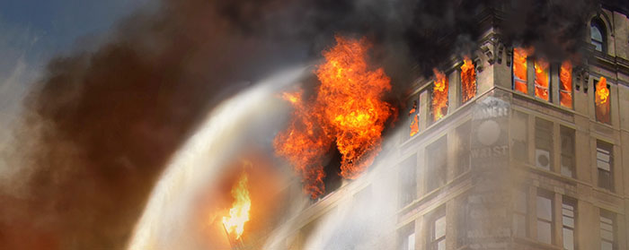 Illustration of flames bursting out of the windows of a building as water is sprayed to put it out