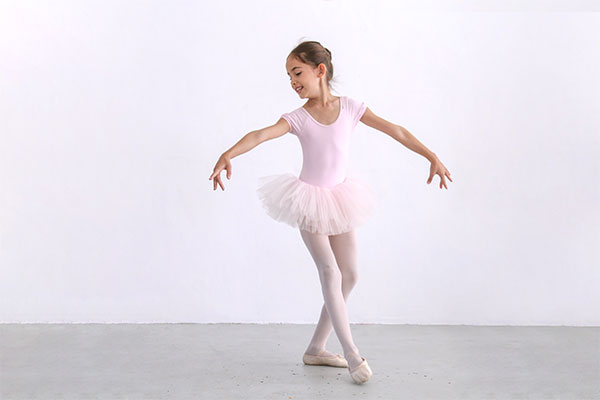 a young ballerina practicing a dance move