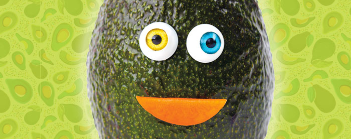 An avocado with a googly eyes and a smile
