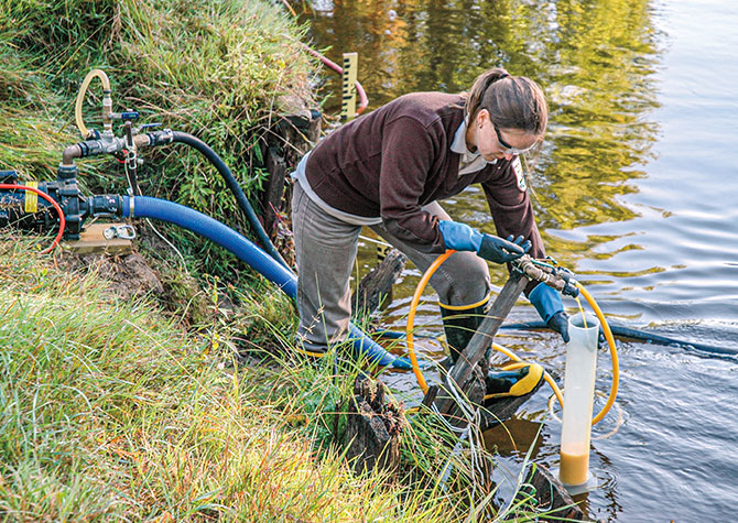 Enlargeable photo of a scientist using a many tubed machines to treat the lake for lamprey